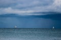 Sailing yacht boat on the sea on horizon under stormy sky with clouds Royalty Free Stock Photo