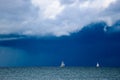 Sailing yacht boat on the sea on horizon under stormy sky with clouds Royalty Free Stock Photo