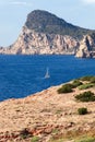 Sailing yacht on bright blue water of Mediterranean Sea against the backdrop of a rearing headland of Cap Nuno Nono Royalty Free Stock Photo