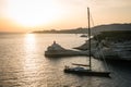 Sailing yacht with lighthouse Madonetta near Bonifacio city at dusk