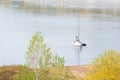 A sailing yacht stands on the water on a windless day