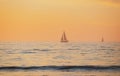 Sailing yacht on sunrise. Calm sea with sunset sky and sun through the clouds over. Ocean and sky background, seascape. Royalty Free Stock Photo