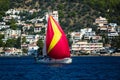 Sailing yacht under red gennaker goes along the Greek coast. Royalty Free Stock Photo