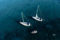 Sailing yachts anchored in blue sea, top view. Sailing yacht on dark background, aerial view