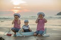 Sailor baby boy, cute child, playing on the beach with wooden boat, fishes and fishing rod on sunset Royalty Free Stock Photo