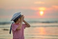 Sailor baby boy, cute child, playing on the beach with wooden boat, fishes and fishing rod on sunset Royalty Free Stock Photo