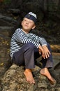 Sailor boy sitting on a stone Royalty Free Stock Photo