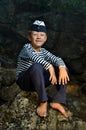 Sailor boy sitting on a stone Royalty Free Stock Photo