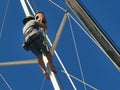 A sailor climbing up to fix the sail boat mast in Kudat, Malaysia. Royalty Free Stock Photo