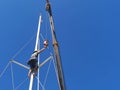 A sailor climbing up to fix the sail boat mast in Kudat, Malaysia. Royalty Free Stock Photo