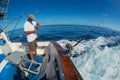 Sailor gets ready reels and rods for marlin game fishing at sea near Saint-Denis, Reunion island.