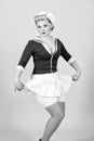 Sailor girl in pin-up style with white skirt. Vintage styled blonde woman isolated on gray background