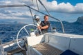 Sailor at the helm of modern sailing yacht