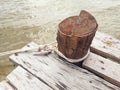 Sailor knot tied on wooden bollard. Bollard on wooden planks in murky waters of the Mekong. Close up of old wooden mooring post Royalty Free Stock Photo