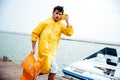 Sailor man in yellow cloak walking at the sea pier Royalty Free Stock Photo