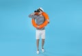 Sailor with orange ring buoy looking through binoculars on light blue background Royalty Free Stock Photo