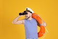 Sailor with orange ring buoy looking through binoculars on yellow Royalty Free Stock Photo