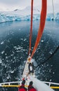 Sailor standing on mast of sailing boat yacht in Antarctica, adventure travel Royalty Free Stock Photo