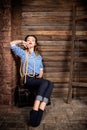 Sailor woman in striped vest and rope sitting on dower chest on wooden background Royalty Free Stock Photo