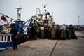 sailors folding their nets in the african fishing harbor next to a wholesale market