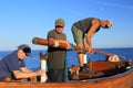 Sailors holding wooden spar