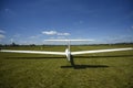 Sailplane landing on a grass, sunny day in Szczecin. Royalty Free Stock Photo