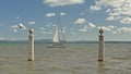 Sailboat on river Tagus with pillars of Cis da colunas quay in front, Lisbon