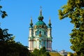 Saint Andrew`s Church on the top of the green hill. Tree leaves border. Natural frame. Blue sky background Royalty Free Stock Photo