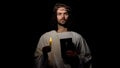 Saint in crown of thorns holding candle and holy bible, christian faith in god Royalty Free Stock Photo