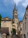 Narrow street in the village center of Saint-Emilion with the Collegial Church bell tower in the background