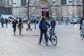 Saint- Gilles, Brussels Capital Region - Belgium- Cycling woman and pedestrians walking over the old market square Parvis