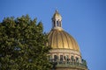 Saint Isaac`s Cathedral golden cupola dome, granite columns, statues behind green trees