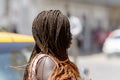 Unidentified Senegalese woman with braids walks along the stree