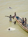 Saint-Louis, Senegal - October 20, 2013: Unidentified African children and grown man swimming next to wooden boat Royalty Free Stock Photo