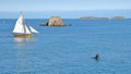 A corsair boat named Le Renard sailing in the bay of Saint Malo with Petit Be Island in the background and a diving board subme