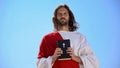 Saint man holding Bible against sky, faith and religion concept, catholicism