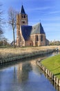 Saint Michel church reflected in a canal at sunny daybreak, Ravels, Flanders, Belgium Royalty Free Stock Photo