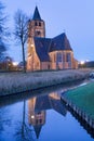 Saint Michel church reflected in a canal at twilight, Ravels, Flanders, Belgium