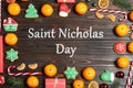 Saint Nicholas Day. Frame made with tasty Christmas cookies and tangerines on wooden background, flat lay Royalty Free Stock Photo