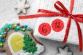 Saint Nicholas Day. Wrapped gift box with date December 6 and gingerbread cookies on snow, flat lay Royalty Free Stock Photo