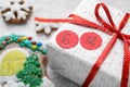 Saint Nicholas Day. Wrapped gift box with date December 6 and gingerbread cookies on snow, closeup Royalty Free Stock Photo
