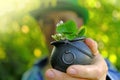 Saint Patrick .clover leaf in bowler hat with gold coins in the hand of a man in a green hat in a sunny garden.Four-leaf