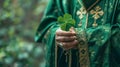 Saint Patrick in green clerical vestments holding a shamrock for preaching, close-up. Holiday Saint Patrick's Day