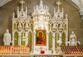 Saint Patrick`s Cathedral White Altar With Candles and Picture of Holly Mary Holding Jesus Christ. Interior Church Decoration in