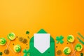 Top view photo of green open envelope with letter meringue candies gold coins straws shamrocks and Royalty Free Stock Photo