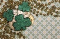 St. Patrick`s Day Themed Background with Beads, Coins and Shamrocks on Patterned Green Backdrop