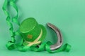 Saint Patrick`s Day image of sparkly green and gold leprechaun hat with curls of green and gold ribbon on a green background with Royalty Free Stock Photo