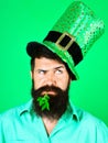 Saint Patrick's Day man. Bearded man in leprechaun hat with clover in mouth. Pensive man in top green hat. Ireland Royalty Free Stock Photo