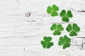 Saint Patricks Day background with green shamrock on white wooden texture top view.