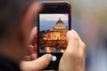 Saint Peter in Vatican, Rome picture appears on tablet, smartphone in man`s hands. Blurred background